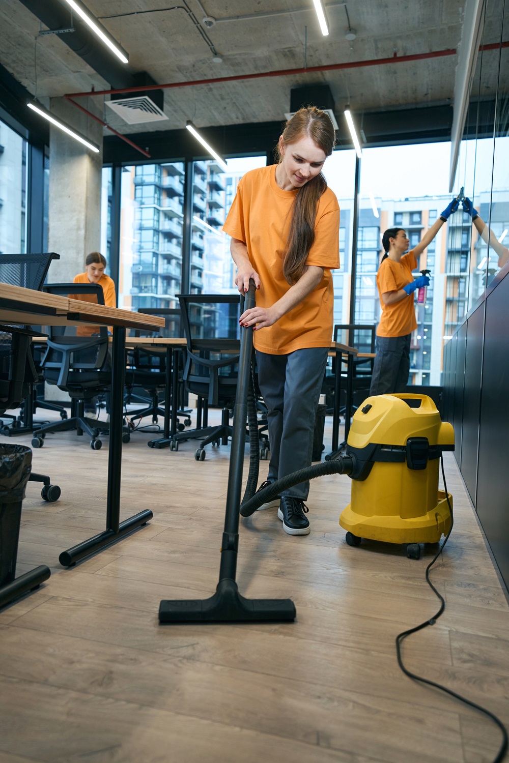 Energetic cleaning company team in uniform washes and disinfects coworking space